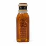 Honey Feast Lavender 8oz Muth glass honey gift jar with a natural tapered cork, hand-dipped beeswax finish and matte yellow-bordered neck label, front view on white.