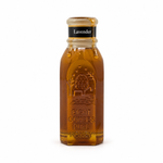 Honey dripping from the open wax-covered rim of Honey Feast Lavender Honey in an 8oz Muth glass jar on white.