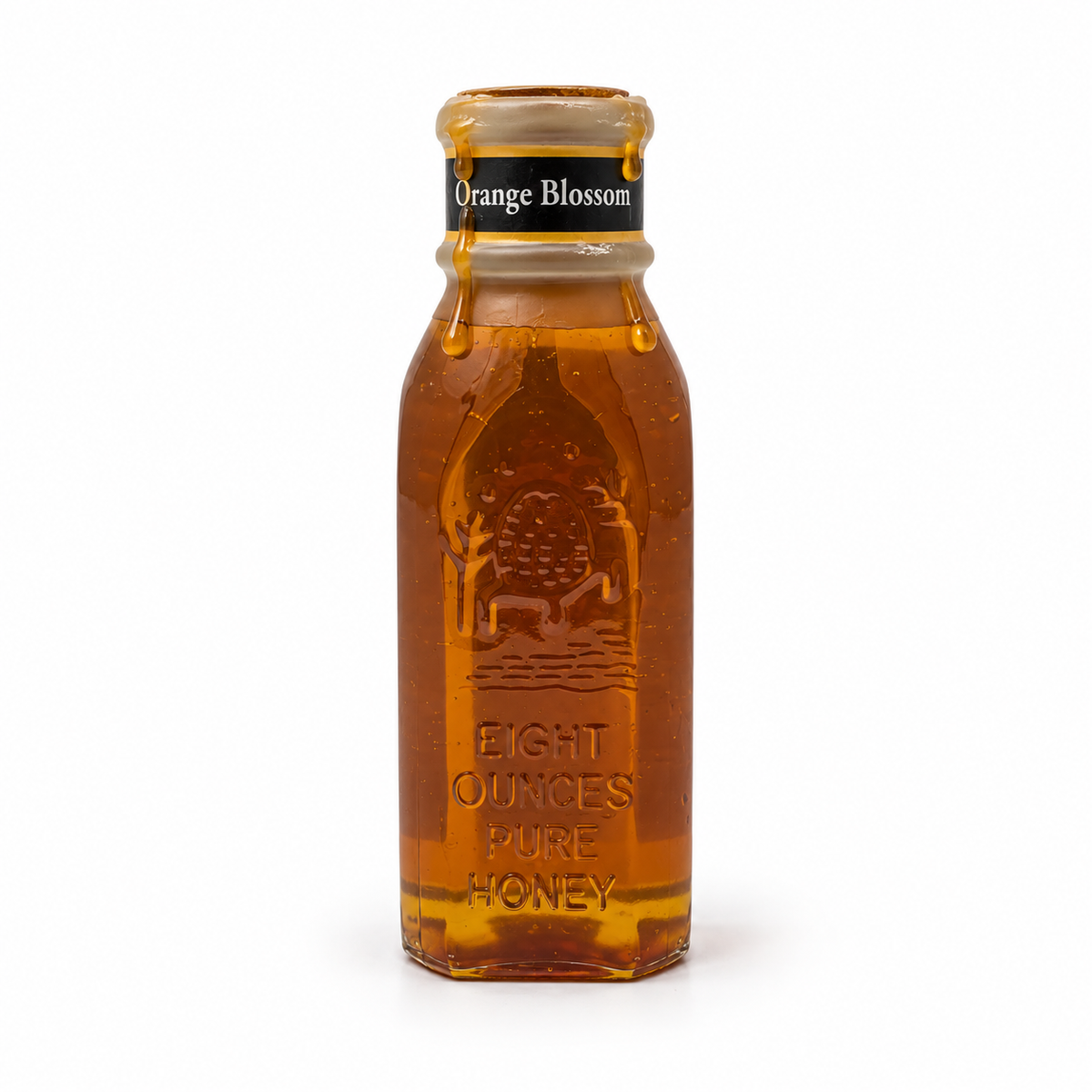 Honey dripping from the open wax-covered rim of Honey Feast Orange Blossom Honey in an 8oz Muth glass jar on white.