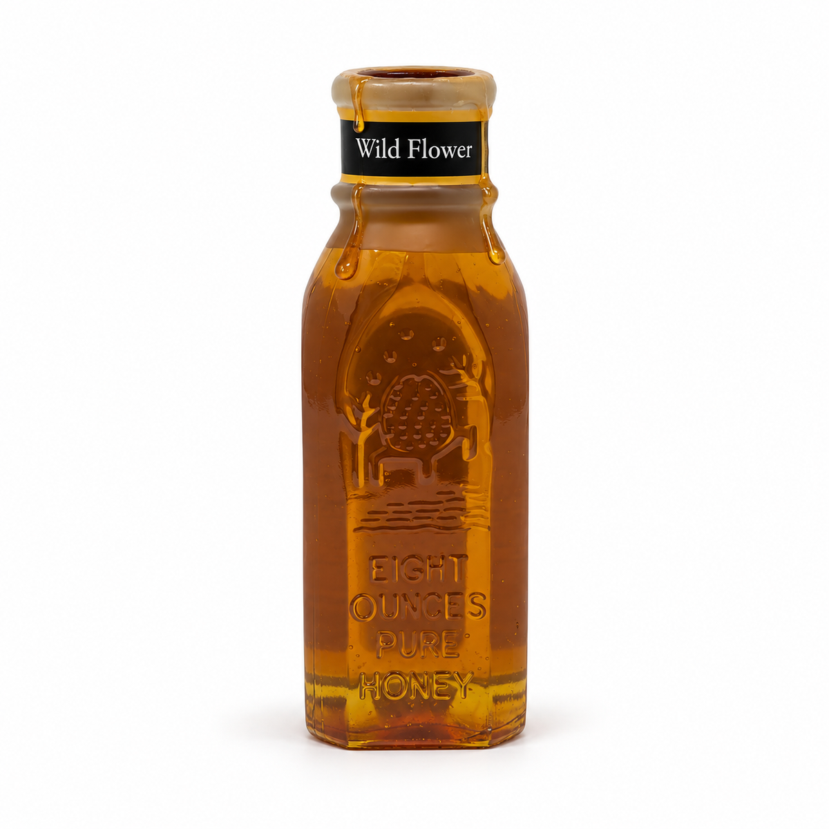 Honey dripping from the open wax-covered rim of Honey Feast Wildflower Honey in an 8oz Muth glass jar on white.