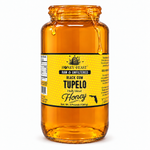 Honey Feast Black Gum Tupelo honey in an open 3lb glass jar, with honey dripping over the rim, on a white background.