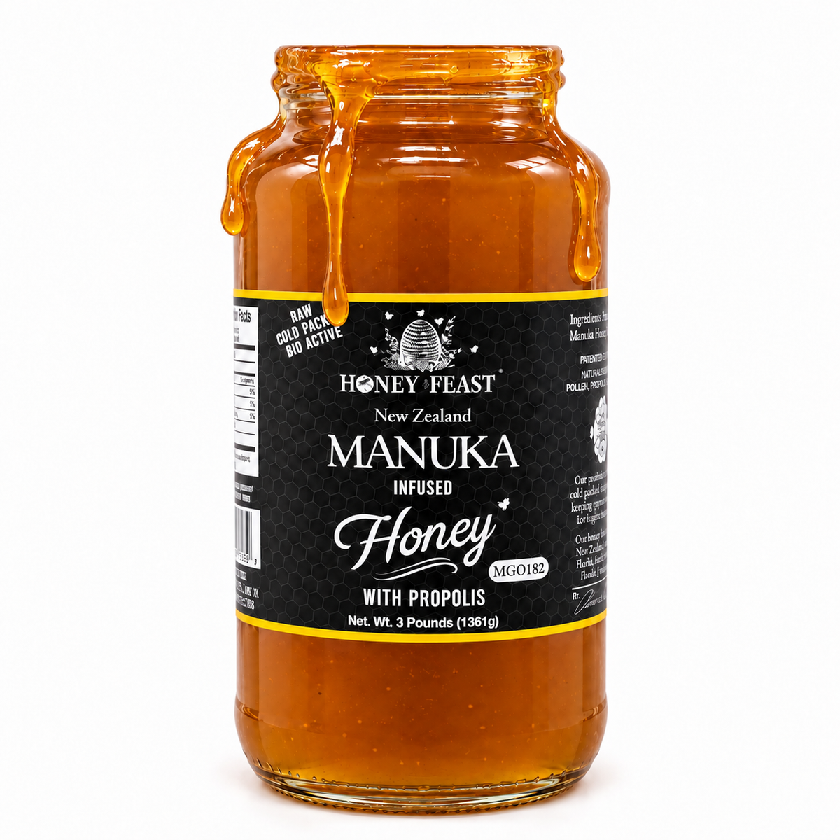 Honey Feast Manuka Infused Honey with Propolis in an open 3lb glass jar, with honey dripping over the rim, on a white background.