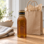 Honey Feast Bourbon Honey 8oz Muth glass gift jar with a cork and hand-dipped beeswax finish, in a simple gifting scene.