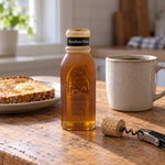 Honey Feast Bourbon Honey 8oz Muth jar open beside food, with its removed tapered cork on a wine corkscrew.