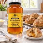 Honey Feast Wildflower Honey – 3lb Glass Jar beside freshly baked wholegrain rolls