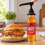 Hot Honey glass jar with an optional pump dispensing honey onto a chicken sandwich; pump sold separately