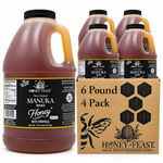 Honey Feast Manuka Infused with Propolis honey 4-pack of 6lb frosted HDPE plastic jugs with wide black screw caps, shown with the branded shipping carton on a white background.