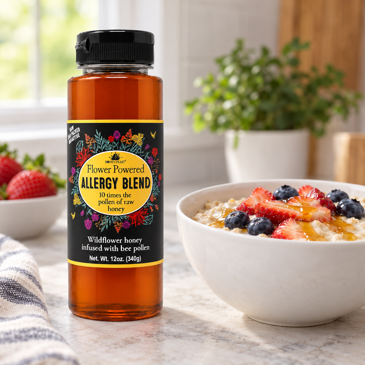 Honey Feast Allergy Blend Honey 12oz plastic squeeze bottle beside a white breakfast bowl topped with strawberries, blueberries and honey