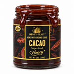 Open 12oz glass jar of Honey Feast cacao honey with thick chocolate-colored honey flowing over the rim