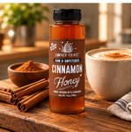 Honey Feast Cinnamon Honey 12oz plastic bottle beside coffee and cinnamon sticks