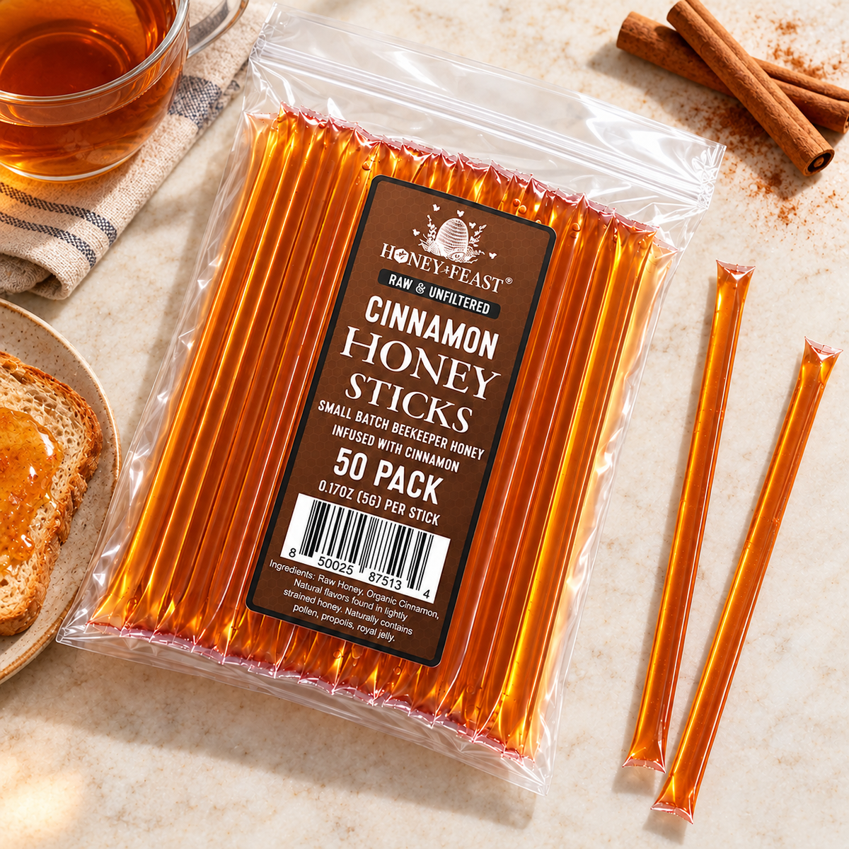 Cinnamon Honey Sticks 50-pack lying flat beside cinnamon, toast and tea with full-length loose sticks