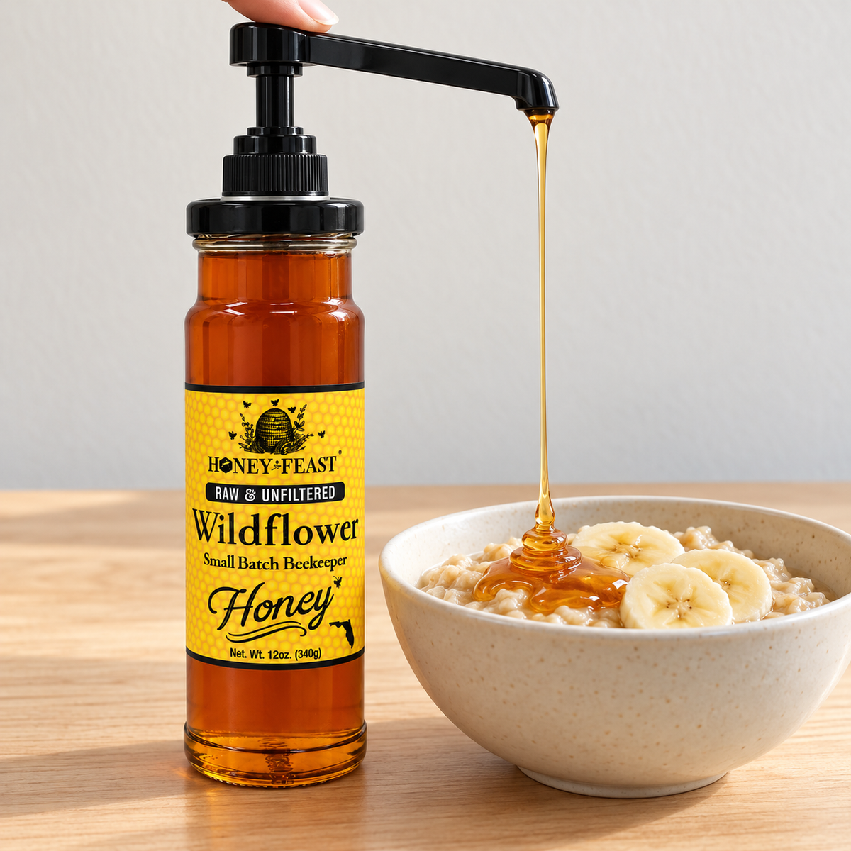 Honey Feast Clean & Easy Honey Pump installed on a compatible tall 12oz Wildflower Honey glass jar beside oatmeal; honey and jar sold separately