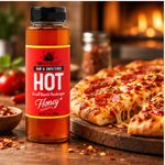 Honey Feast Hot Honey 12oz plastic bottle beside pizza and chili peppers