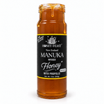 Honey Feast Manuka infused honey with propolis in an open 12oz glass jar with honey dripping down the side