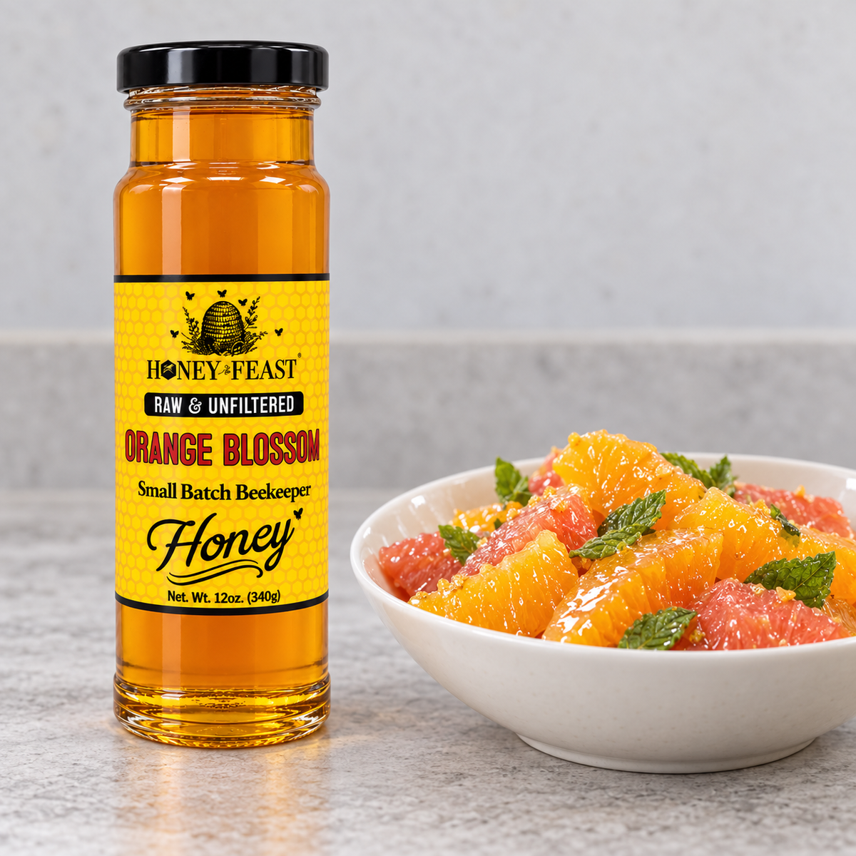 Honey Feast Raw Orange Blossom Honey 12oz glass jar beside a citrus salad