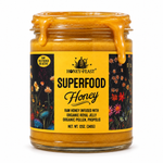 Open 12oz glass jar of Honey Feast Superfood Honey with thick honey flowing over the rim