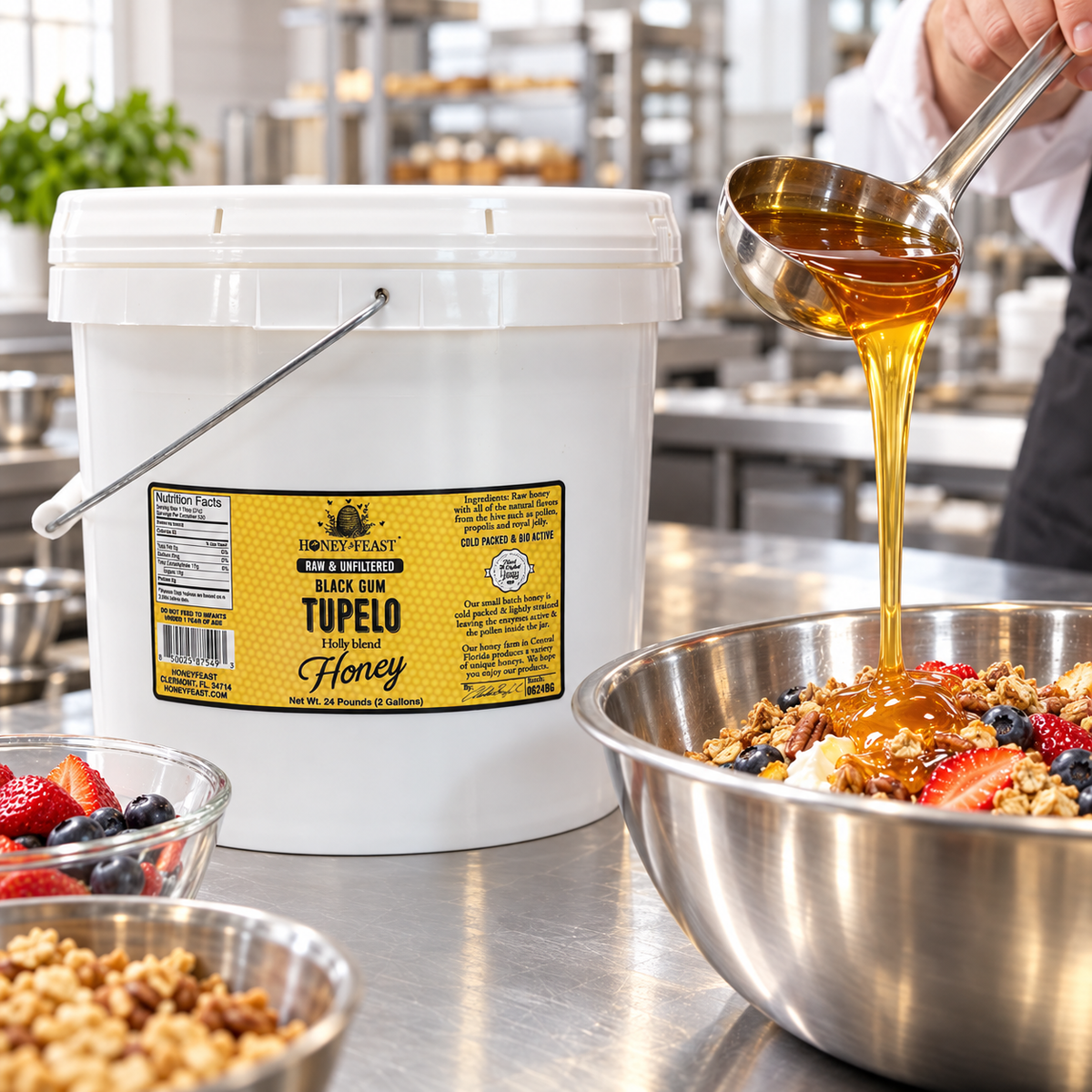 Honey Feast Black Gum Tupelo Honey 2-gallon bucket in a commercial kitchen as a cook ladles honey into a stainless steel mixing bowl.