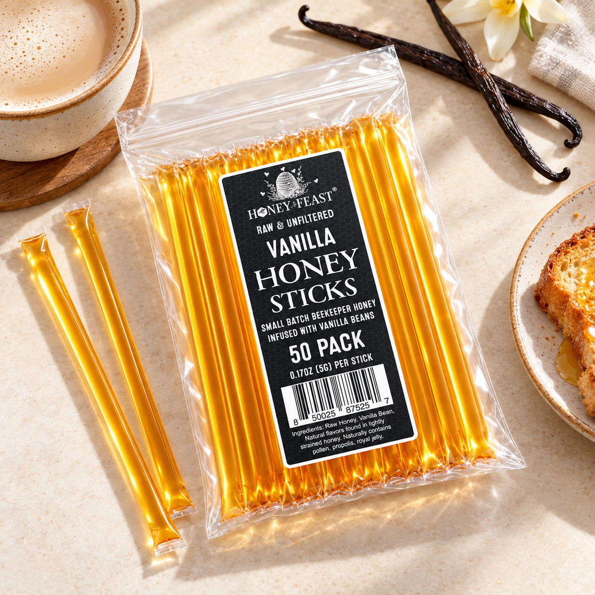 Vanilla Honey Sticks 50-pack lying flat beside vanilla beans, coffee and toast with full-length loose sticks
