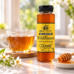 Honey Feast Wildflower Honey 12oz plastic squeeze bottle beside tea and honey in a simple lifestyle setting